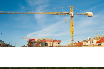 Blank banner for advertisement on the fence of construction site with cranes. Sunny day with blue sky. © diesirae