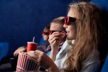 Female teen in 3d glasses resting with friends in cinema