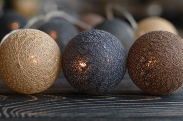 Cozy brown garland knitted background lanterns balls interior decor close up.  