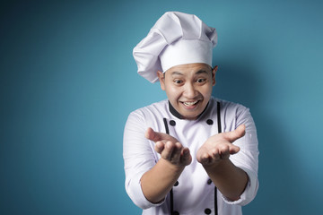 Happy Asian Chef Presenting Something on His Empty Hands