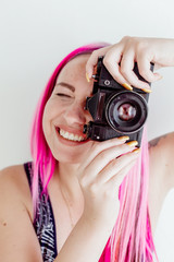 photographer girl with pink hair on a photo shoot with a camera