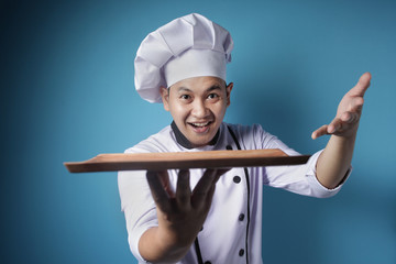 Asian Male Chef Shows Empty Wooden Plate, Presenting Something, Copy Space