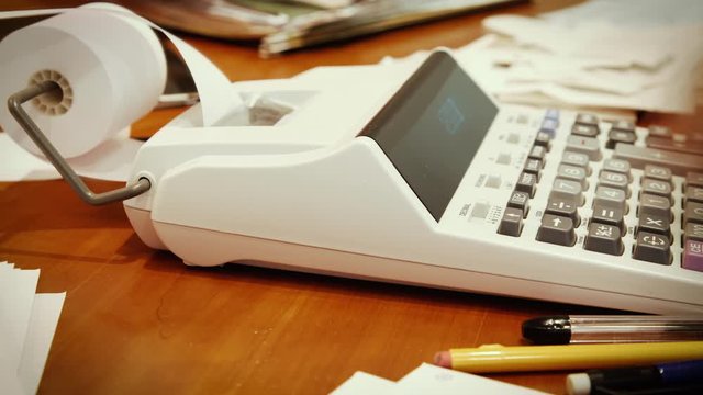 Close up of a man's hand, hard at work using a calculator.