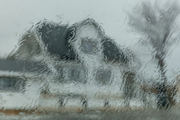 Dwelling house through wet window, autumn day. texture