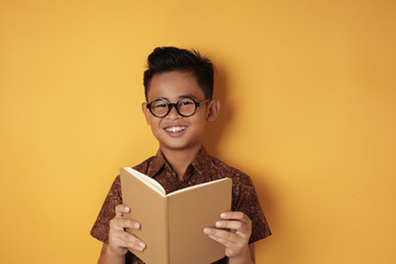 Smart Asian Boy Smiling While Reading Book