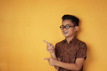 Asian Boy Pointing to The Side with Copy Space