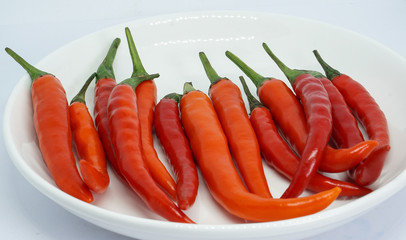 organic red chili pepper in dish isolated on white background