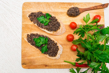 Fresh tasty bruschetta with truffle sauce, parsley and tomates. Top view