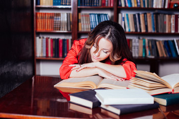 girl is preparing for the exam in the library reads books