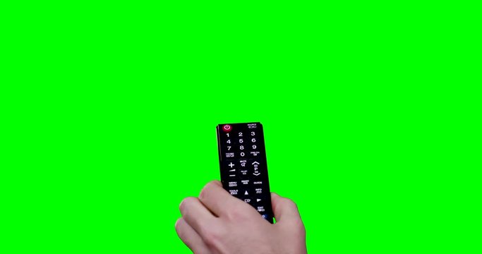 man's hand holding a remote controller turns up the sound and switching channels with green screen in background shot in 4k one click keyable 