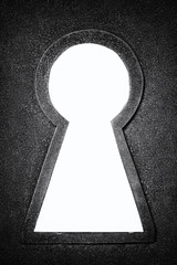 Black and white photo of a rusty metallic keyhole isolated on the white background