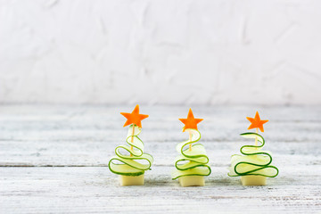 Creative set christmas trees of cucumber, cheese and star of carrot. Funny kids food for new year party with copy space