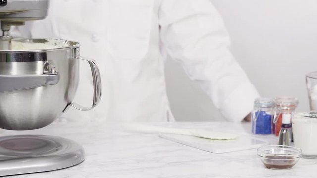 Step by step. Mixing ingredients in standing kitchen mixer to make buttercream frosting.