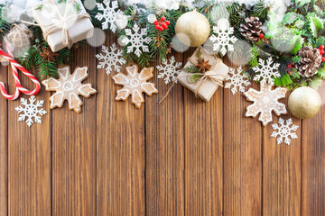 Christmas gifts, Christmas decorations, Christmas tree branches and snowflakes on a wooden background. Flat lay style