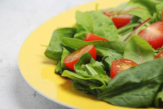 A plate with green salad and cherry tomatoes	