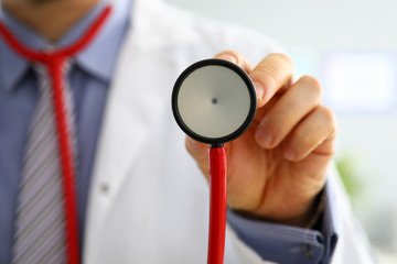 Male medicine doctor hand holding stethoscope head closeup