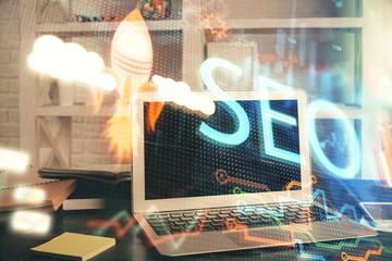 Multi exposure of table with computer and seo drawing hologram. Search optimization concept.