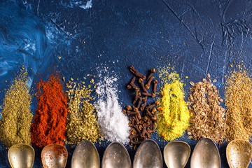  Various spices ground turmeric pepper ginger cinnamon herb seasoning salt paprika caraway seeds on the table. View from above. fragrant indian spices