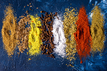  Various spices ground turmeric pepper ginger cinnamon herb seasoning salt paprika caraway seeds on the table. View from above. fragrant indian spices