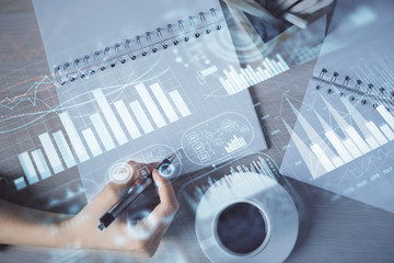 Multi exposure of woman's hands making notes with forex graph hologram. Concept of technical...