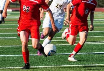 High school soccer team on a breakaway with both teams running down the field