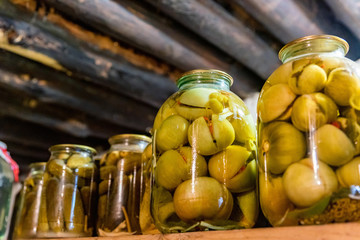 Close up pickled tomatoes and cucumbers in glass jars close
