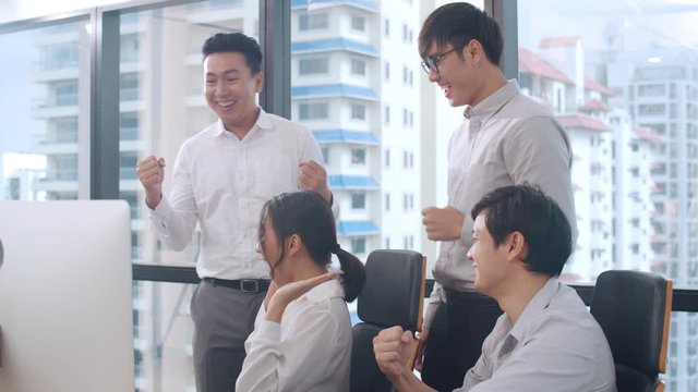 Millennial group of young businesspeople Asia businessman and businesswoman celebrate giving five after dealing feeling happy and signing contract or agreement at meeting room in small modern office.