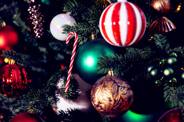 Christmas background tree branch with decorations candy lollipop cane red and green balls, with bokeh light