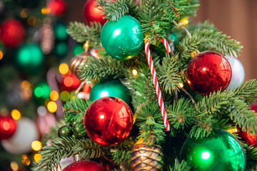 Christmas background tree branch with decorations candy lollipop cane red and green balls, with bokeh light