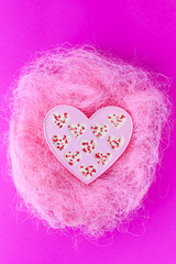 Candy hearts made of white chocolate and sublimated strawberries on a pink background.