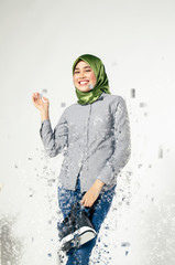 Amazed young women wearing virtual reality goggles dispersing into pixels effect over abstract...