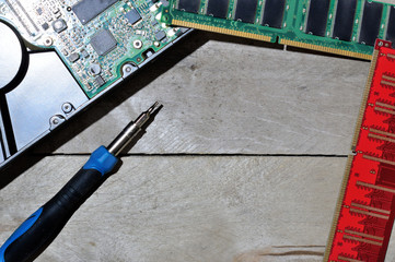 disassembling the hard drive with a screwdriver. top view. wooden background.
