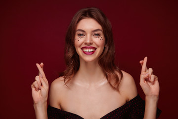 Portrait of young lovely blue-eyed brunette female with wavy hairstyle in festive clothes...