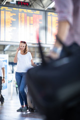 Young woman with her luggage at an international airport, before going through the check-in and the security check before her flight