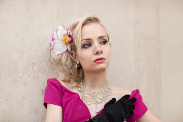 Junge Frau mit pinken Kleid und Hibiskusblüte im Haar  © Julie Boehm