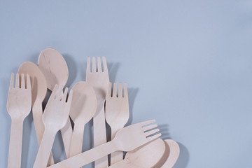Brown wooden spoons and forks -cutlery lie on a gray background. The concept of environmental...