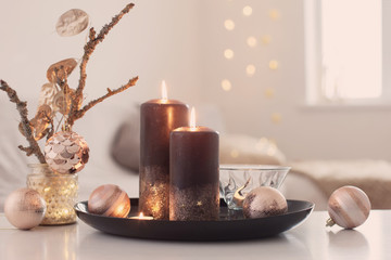 black burning candles with Christmas balls in white interior