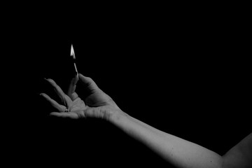 Burning match held in between fingers