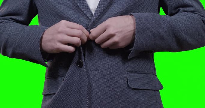 close up of man dressing up his suit with greenscreen in background shot in 4k one click keyable