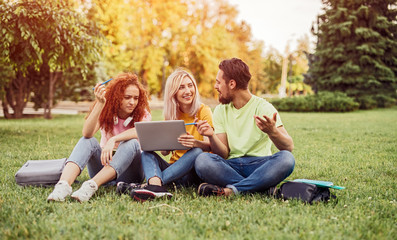 Young students discussing homework in park