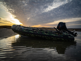 An Inflatable Zodiac at Sunrise with Calm Water and Clouds