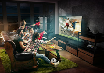 Group of friends watching TV, football match, sport together. Emotional men and women cheering for favourite team, look on goal and fighting for ball. Concept of friendship, leisure activity, emotions