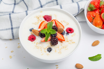 Yogurt with granola, fresh strawberries, raspberry, blueberries, blackberries, almonds and mint. Healthy snack. Breakfast food. 