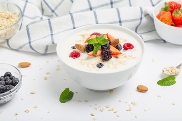 Yogurt with granola, fresh strawberries, raspberry, blueberries, blackberries, almonds and mint. Healthy snack. Breakfast food. 