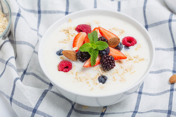 Yogurt with granola, fresh strawberries, raspberry, blueberries, blackberries, almonds and mint. Healthy snack. Breakfast food. 
