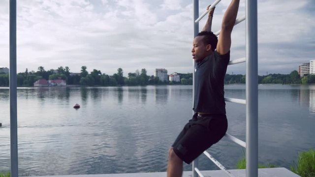 Young fitness afro man doing abs exercises outdoors