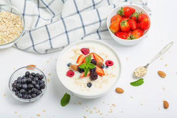 Yogurt with granola, fresh strawberries, raspberry, blueberries, blackberries, almonds and mint. Healthy snack. Breakfast food. 