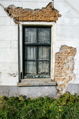 Fototapeta na wymiar Window in abandoned ruin with white wall.