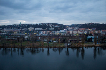 Fototapeta na wymiar Winter panorama from Vysehrad Castle to the evening city of Prague, residential areas, the Vltava River, moorings with boats and boats and city transport.