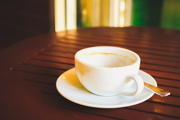 Empty coffee cup after drink on wood table.